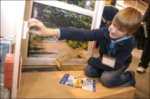 7-летний Максим, сын менеджера Галины Заграничной, регулирует термостат напольной батареи на выставочном стенде компании ”Хитинг Киев”