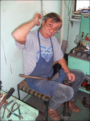 Обувной мастер из Полтавы Аркадий Кесельман в собственной мастерской набивает набойки на осенние женские сапоги. За работу берет 10 гривен