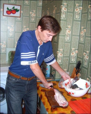 Сергей Назаренко нарезает рыбину кусками, чтобы замариновать в уксусе, соевом соусе и луке, добавляет много приправы для рыбы 