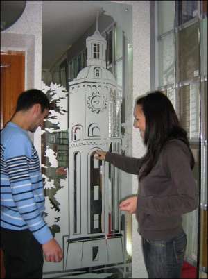 Посетители мастерской ”Ситиф” в Кирпичном переулке рассматривают зеркало с выгравированным винницким пейзажем  ”Городская ратуша”