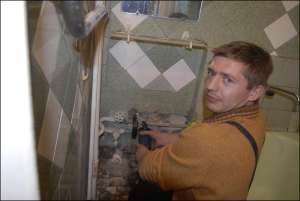 Работник фирмы ”Сантехник” Юрий Кириленко разбирает старые трубы в квартире на столичном жилищном массиве Нивки