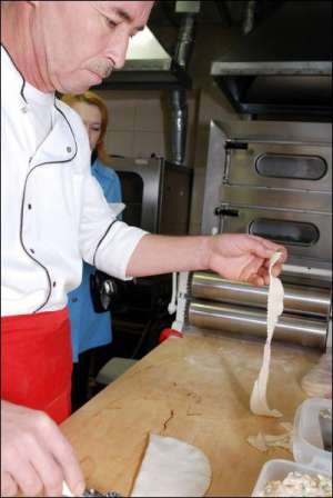 Шеф-кухар столичного ресторану ”Тюбетейка” Наріман Аблямітов обтинає ножем-коліщам краї чебурека