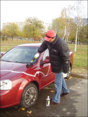 Киевлянин Игорь Губанович оттирает аэрозоль с машины ”Шевроле Лачетти”