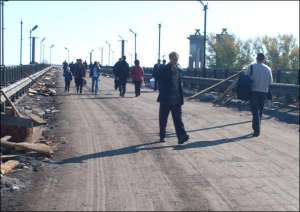 У Кременчуці через ремонт єдиного мосту через Дніпро місяць не пропускають автотранспорт. Люди його перетинають пішки або залізницею по нижньому ярусу