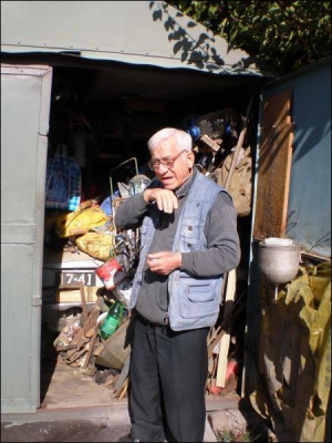Пенсіонер Василь Цісар біля свого гаража в Луганську. У старому ”запорожці” облаштував ліжко, за машиною — столик зі світильником