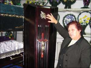 Завідувачка магазину ритуальних послуг Ольга Соляник із Решетилівки показує найдорожчу домовину з мореного дуба за 1700 гривень. Її привезли із Закарпаття