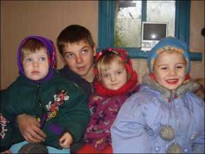 Восьмиклассник Анатолий Слободенюк обнимает родных сестер Софию (слева), Марию и Алису (справа)