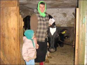 Оксана Заболотная из села Худяки Черкасского района возле коровы Горошины, которую с мужем получили в мае. Рядом с женщиной 2-летний сын Илья