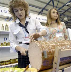 Анна Склярова из компании ”Италимпорт” угощает посетителей выставки итальянской колбасой с фисташками ”Мортаделла”