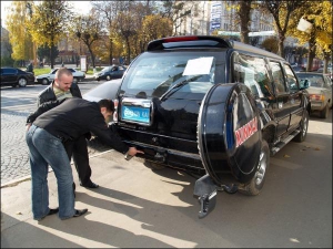 Менеджер автосалона Александр Коновалов показывает винничанину багажник китайского джипа ”Ксинкай”. Он запирается специальным электронным замком. На задней панели снаружи установлена небольшая видеокамера, чтобы водитель мог видеть дорогу позади
