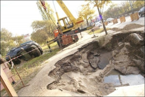 24 октября, ул. Борщаговская. Автомобиль вытянули из подмытой водой ямы на тротуаре через полдня после аварии