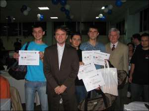 Слева направо: украинские студенты Остап Коркуна, Руслан Бабиля, Василий Билецкий (с дипломами) рядом с членами жюри после объявления результатов олимпиады по программированию в Бухаресте