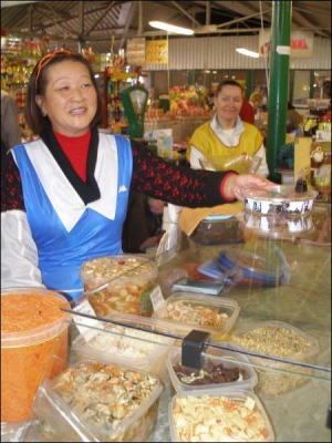 Львів’янка Наталя Кім виставляє на прилавок салати з овочів та морепродуктів. Продає їх від 1 до 6 гривень за 100 грамів