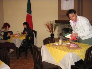 В винницком ресторане ” ”Тірамісу”” итальянец Лучио Ферреро демонстрирует три самых популярных в Италии вида сыра — горгонзолу, моцареллу и гамбо. Рядом лежит кусок свиного бедра холодного копчения. Итальянцы называют его прошутто крудо