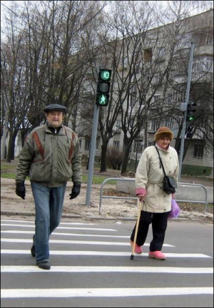 У Черкасах на перехресті Ільїна та Богдана Хмельницького пішоходи йдуть через дорогу. Позаду видно новий світлофор із табло, що показує секунди до зміни сигналу. Нових світлофорів не ставили в обласному центрі 10 років