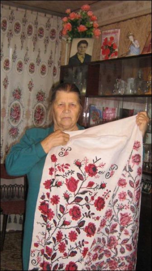 Мотрона Косецька з села Геронимівка, що поблизу Черкас, показує рушник, який їй подарувала тітка Катерина. Рушникові майже сто років