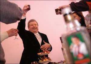 Михайло Поплавський піднімає чарку горілки ”Кропива”, але не п’є. Бере вишневий сік, відпиває кілька ковтків