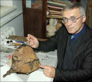 Богдан Прищепа у Рівненському краєзнавчому музеї показує шолом, який склеїв ебоксидною смолою