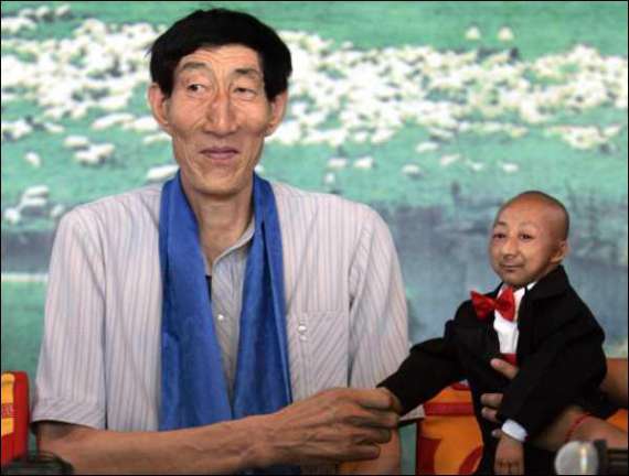 Самый высокий человек в мире Бао Ксишун (2м 36 см) пожимает руку самому маленькому человеку на планете Хи Пингпингу (73 см).