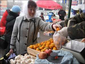 Хмельничанка Раиса Прозуровская берет килограмм грузинских мандаринов на продуктовой аллее возле вещевого рынка по Львовскому шоссе. Говорит, на Новый год будет брать не меньше 7 килограммов