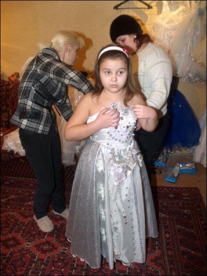 9-річна Неля Первак із мамою вибирають плаття на новорічний ранок у школу.  Вбрання, що сподобалося дівчинці, на неї мале. Майстриня Світлана Чернишова пояснює, як вона його розширить