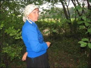 Ганна Зварич із села Сировари Тернопільської області показує місце поблизу своєї хати, де знайшли кістки людини