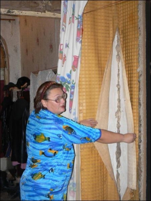 Уманчанка Ирина Островская в собственной квартире на Советской, 13 показывает стену, которая треснула из-за строительства соседнего дома. Женщина повесила ковер, потому что сквозь дыру гуляет сквозняк