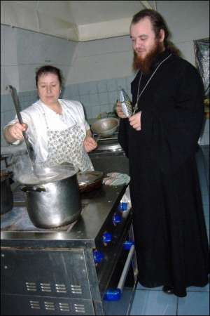 Вера Зубко помешивает гречневый суп на кухне в Спасо-Преображенском монастыре в Новгороде-Сиверском. Готовить женщине помогает игумен Никодим