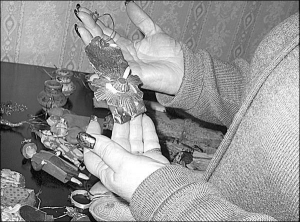 Відповідальна за фонди музею письменника Володимира Короленка в Полтаві Людмила Ольховська тримає в руках 100-річну ялинкову прикрасу-орден. На задньому плані — іграшки ручної роботи. Вони висіли на ялинці родини Короленка. Такі раніше продавали в магазин