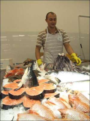 Продавец Игорь Лопатинский раскладывает морепродукты на прилавке нового гипермаркета ”Подоляне” в Тернополе 