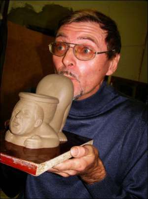 Скульптор Олег Рябо целует глиняный эскиз унитаза, который он сделает за 6 тысяч евро по заказу бизнесмена из Объединенных Арабских Эмиратов