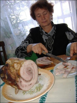 Полина Секера тонко нарезает рулет из свиной подчеревины. Хозяйке нравится, когда он с мясом