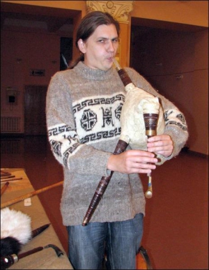 Киянин Олексій Кабанов грає на старовинному українському музичному інструменті ”коза” в фойє філармонійного центру в Чернігові