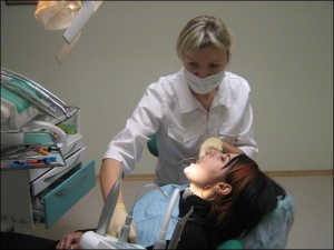 Лікар-стоматолог івано-франківської приватної клініки Михайлюка Надія Микитюк лікує карієс жительці обласного центру Галині Бартос