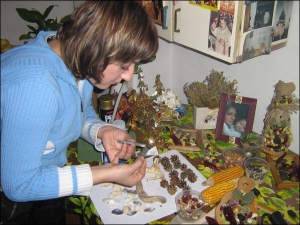 Ольга Ястремська робить оберіг на дерев’яній кухонній дощечці. Приклеює на неї качани кукурудзи та квасолю