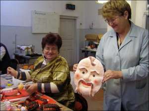 59-летняя Мария Соломка (справа), начальник участка карнавальных масок на фабрике ”Ривненчанка”, показывает изделия, которые в Украине изготовляет лишь это предприятие. Рядом Надежда Василевич, 49 лет, работает над куклами