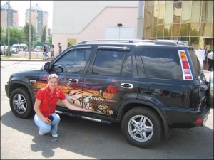Менеджер компании ”Автомагия” Леся Совенко показывает на выставке ”СИА-2007” легковик ”хонда”, оформленный виниловым стайлингом – изображением тигра 
