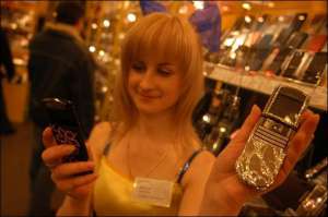 Анастасия Мололкина из столичного магазина ”Евросеть” показывает телефоны, украшенные стразами Сваровски. В правой руке она держит украшенный ”Самсунг U600” за 4999 гривен, в левой — ”Нокию 8800 Сирроко” за 9900 гривен