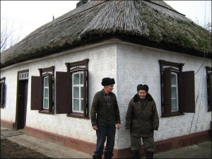 Анатолій Козина (ліворуч) із батьком Василем Микитовичем біля власноруч збудованої та укритої очеретом хати