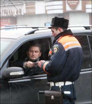 Столичный сотрудник ГАИ проверяет у водителя наличие страхового полиса. Штраф за его отсутствие — от 8,5 до 17 гривен