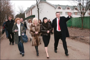 Главврач онкобольницы на улице Верховинной Геннадий Олиниченко сопровождает заместителя мэра Ирену Кильчицкую и руководителя управления по вопросам здравоохранения мэрии Людмилу Качурову по дороге от хосписа до онкобольницы. Хоспис расположен сзади них. В