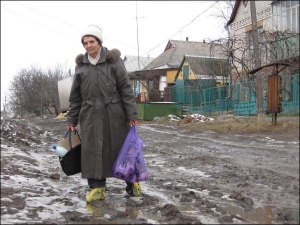 Уманчанка Марія Луба повертається з базару через болото на вулиці Тухачевського. На ногах у жінки целофанові пакети