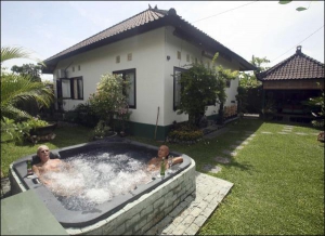 Голландские пенсионеры, которые последние восемь лет живут на индонезийском острове Бали, отдыхают в джакузи возле своего дома на курорте Семиняк