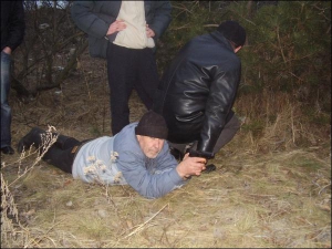 Підозрюваний Віктор Борисполець під час слідчого експерименту на одному з озер масиву Оболонь демонструє слідчим, де і як він пристрілював пістолет ”Дженнінґс”