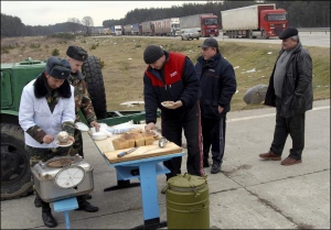 Українські прикордонники дають безкоштовну їжу водіям вантажівок, які чекають на кордоні з Польщею у Краковці, — борщ, гречку з тушкованою свининою, гарячий чай