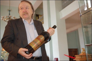 Директор музею подарунків Анатолій Збанацький тримає трилітрову пляшку коньяку, подаровану мерові посольством Грузії. Цей експонат цікавить чоловіків-відвідувачів найбільше