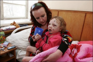 Лилия Елисеева поит дочку Екатерину соком в нейрохирургии областной больницы Донецка. У девочки сломаны обе челюсти, правое плечо, ушиб головного мозга