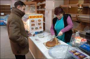 Катерина Максимівна Красна, продавець Дому хліба на вул. Сагайдачного, 16, розрізає 31 січня опівдні одну з останніх хлібин ”Українського”. Відсьогодні, з 1 лютого, цей  магазин не працює