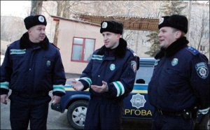 Прапорщик Александр Орел (в центре) показывает, какой величины была новорожденная — ”как котенок”. Слева — Павел Полищук, справа — Сергей Маньковский