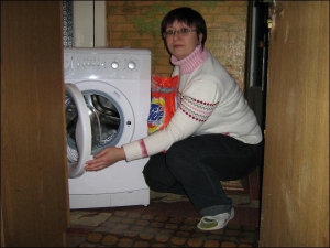 Олеся Січкоріз роздивляється подаровану водоканалом пральну машину. Минулого місяця вона купила пралку цієї ж фірми. Жінка каже, що нову подарує синові на весілля